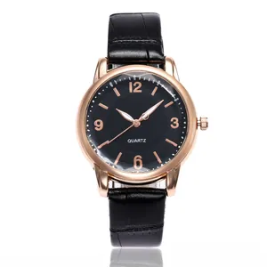 Detail of rose gold quartz watch featuring black leather strap and minimalist black dial