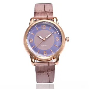 Detail of rose gold quartz watch featuring purple dial and brown faux crocodile leather strap