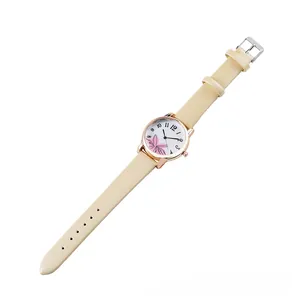 Detail of trendy women's watch with pink flower on white dial and beige faux leather strap