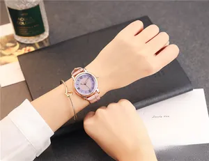 Close-up of rose gold minimalist watch with pink leather strap and knot bracelet
