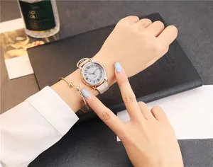 Close-up of rose gold quartz watch with beige leather strap and matching bracelet