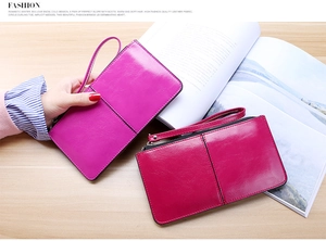 Glossy leather long wallets with zippers and wrist straps in purple and red colors