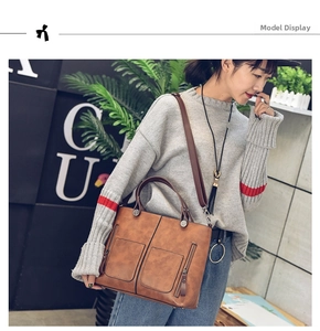Detail view of a vintage brown PU leather tote bag shown in a stylish outdoor setting
