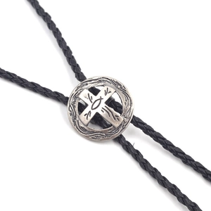 Detailaufnahme der Vintage Bolo Tie Schnalle mit Kreuz und Fischsymbol an schwarzer Lederschnur