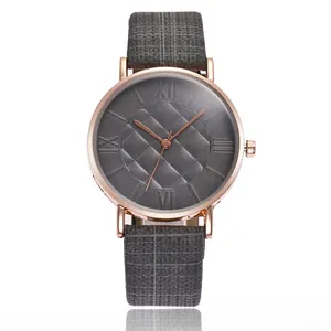 Macro detail of quartz watch with rose gold case, roman dial, and grey woven strap