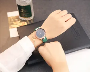 Montre quartz femme avec bracelet cuir vert foncé et jonc doré porté au poignet