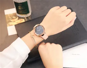 Gros plan d'une montre femme avec boîtier or rose, bracelet cuir rose et cadran gris facetté