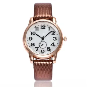 Detail of rose gold quartz watch with brown snakeskin pattern strap and numeric dial