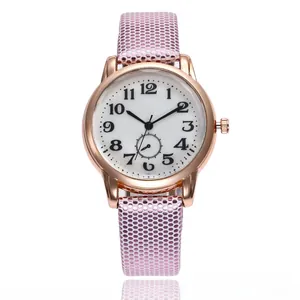Close-up of pink polka dot strap and rose gold quartz watch face with Arabic numerals