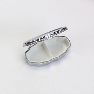 Portable silver oval metal pill case with double compartments and white plastic lining
