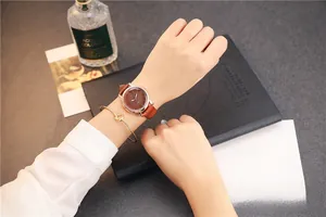 Close-up of elegant rose gold quartz watch with brown leather strap and metal bracelet