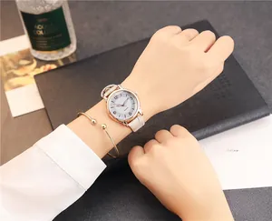 Close-up of minimalist rose gold watch with beige leather strap and gold bracelet set