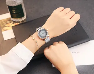 Close-up of a minimalist grey leather strap watch with a matching rose gold cuff bracelet
