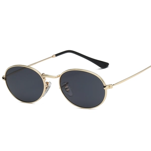 Vintage oval sunglasses with slim gold metal frame and black lenses on white background