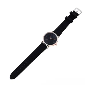 Close-up of thin leather strap watch with rose gold roman numerals and black dial
