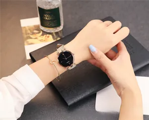 Gros plan d'une montre à quartz pour femme avec cadran noir et bracelet nœud doré