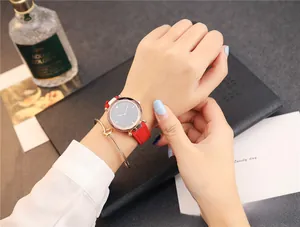 Gros plan d'une montre à quartz pour femme avec bracelet rouge et bracelet doré