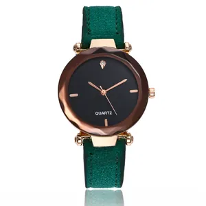 Détail d'une montre à quartz pour femme avec bracelet en daim vert foncé et boîtier or rose