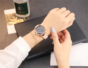 Gros plan sur la montre en cuir rose et le bracelet à nœud en or rose au poignet