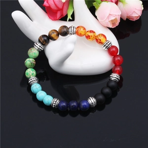 7 Chakras bracelet with tiger eye and agate beads displayed on a ceramic hand model