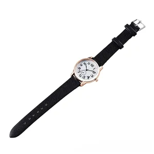 Detail of rose gold quartz watch with retro numeral dial and black textured strap