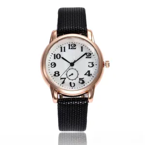 Detail of rose gold watch case with black dotted strap and clear numeric dial