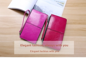 Close-up of two long leather wallets in rose purple and dark red with wrist straps