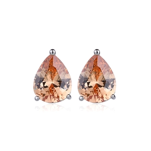 Macro detail of pear-shaped champagne zircon stud earrings with classic 3-prong setting