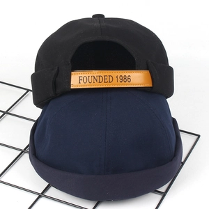 Bonnet miki noir et bleu marine avec broderie 1986 et bride en cuir sur fond blanc