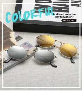 Detail view of oval metal frame sunglasses in silver and gold on a textured surface
