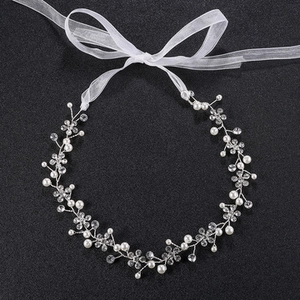Detail of silver bridal headband featuring handmade pearls, beads, and white ribbons