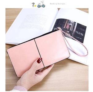 Detailed view of pink leather long wallet with wristlet strap and smooth zipper closure