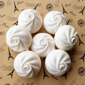 Set of seven white PU slow rebound steamed bun keychains with rings on vintage background
