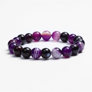 Macro detail of natural purple striped agate beads on an elastic stretch bracelet
