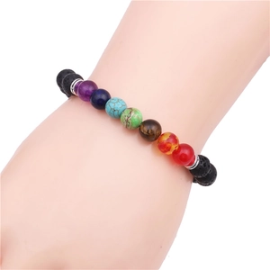Dettaglio del braccialetto chakra in pietra lavica da 8mm indossato da un uomo