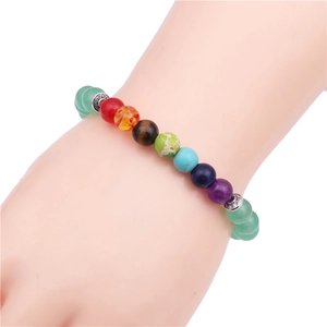 Bracelet en calcédoine verte de 8mm avec pierres de chakra colorées porté au poignet