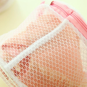 Foldable honeycomb mesh laundry bag for bras featuring a protective pink zipper cover
