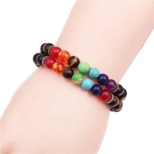 Detail eines doppellagigen Tigerauge- und bunten Steinperlenarmbands am Handgelenk