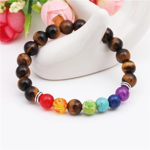 Detailansicht eines Tigerauge-Armbands mit sieben Chakra-Steinen auf Schmuckhalter