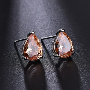 Macro view of teardrop champagne zircon earrings with elegant silver claw setting