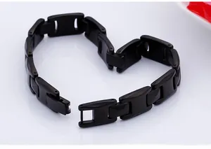 Minimalist black stainless steel link bracelet arranged in a heart shape on white background
