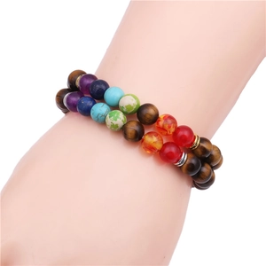 Nahaufnahme von zweilagigen Tigerauge- und Chakra-Stein-Perlenarmbändern am Handgelenk