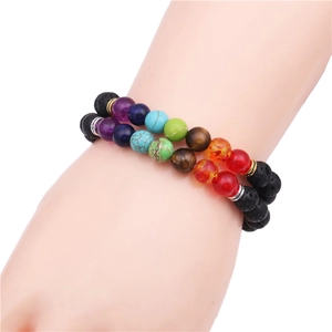 Dettaglio di braccialetti chakra in pietra lavica 8mm su modello con cordino elastico