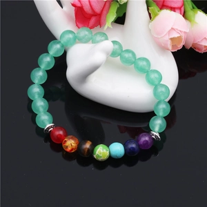 Bracelet perles calcédoine verte 8mm avec sept chakras sur présentoir de main