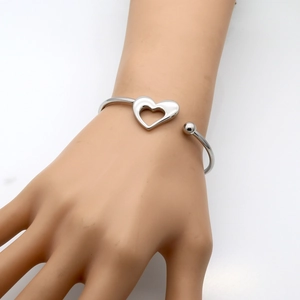 Detailed close-up of a silver hollow heart-shaped stainless steel open cuff bracelet