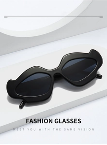 Detail of irregular wave frame sunglasses in black finish on a white geometric stand