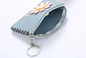 Detail of light blue PU leather coin purse featuring a 3D daisy flower and metal keychain
