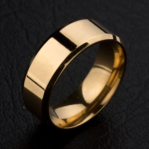 Macro detail of wide gold polished stainless steel ring with smooth chamfered edges