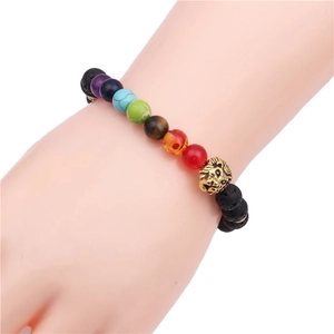 Chakra stone bracelet with 8mm lava rock beads and golden lion head charm on wrist