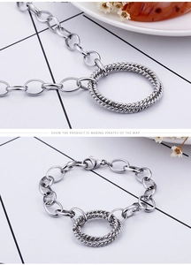 Detail of silver interlocking rings on a textured chain bracelet with lobster clasp